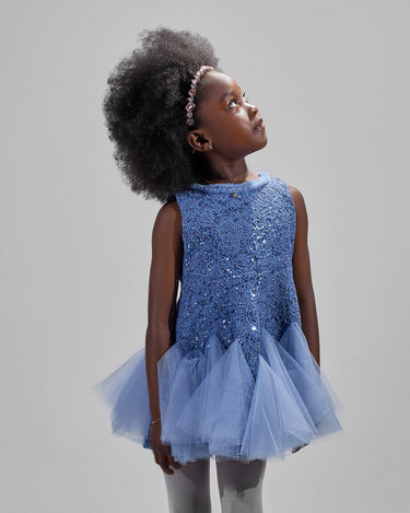 Girl in azure sequin lace dress with dramatic flared tulle hem.