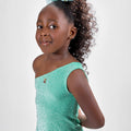 Girl in mint glitter jersey dress with silk organza overshirt and feather trim.