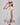Girl in floral and flamingo print dress with scalloped cape and gathered skirt.