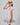 Girl in floral and flamingo print dress with scalloped cape and gathered skirt.