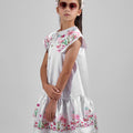 Girl in floral and flamingo print dress with scalloped cape and gathered skirt.