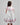 Girl in floral and flamingo print dress with scalloped cape and gathered skirt.