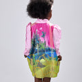Girl in pink top and Dubai desert print skirt with front buttons.