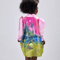 Girl in pink top and Dubai desert print skirt with front buttons.