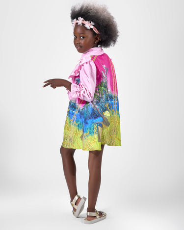 Girl in pink top and Dubai desert print skirt with front buttons.