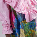 Girl in pink top and Dubai desert print skirt with front buttons.