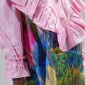 Girl in pink top and Dubai desert print skirt with front buttons.