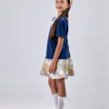 Girl in navy velvet and floral brocade dress with puff sleeves and scalloped detail.