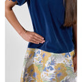 Girl in navy velvet and floral brocade dress with puff sleeves and scalloped detail.