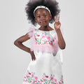 Girl in taffeta A-line dress with flamingo print, tulle sleeves, and back bow.