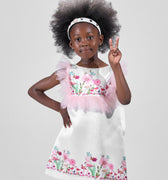 Girl in taffeta A-line dress with flamingo print, tulle sleeves, and back bow.