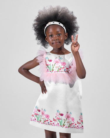 Girl in taffeta A-line dress with flamingo print, tulle sleeves, and back bow.