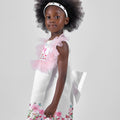 Girl in taffeta A-line dress with flamingo print, tulle sleeves, and back bow.