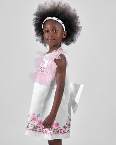 Girl in taffeta A-line dress with flamingo print, tulle sleeves, and back bow.