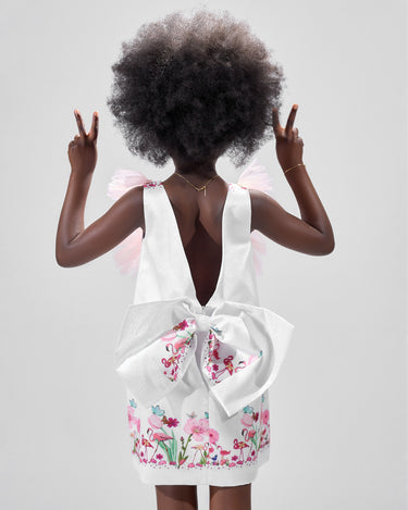 Girl in taffeta A-line dress with flamingo print, tulle sleeves, and back bow.