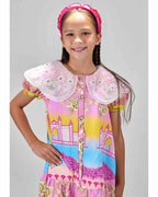 Girl in Dubai skyline print shirt dress with lace collar and puff sleeves.