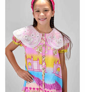 Girl in Dubai skyline print shirt dress with lace collar and puff sleeves.