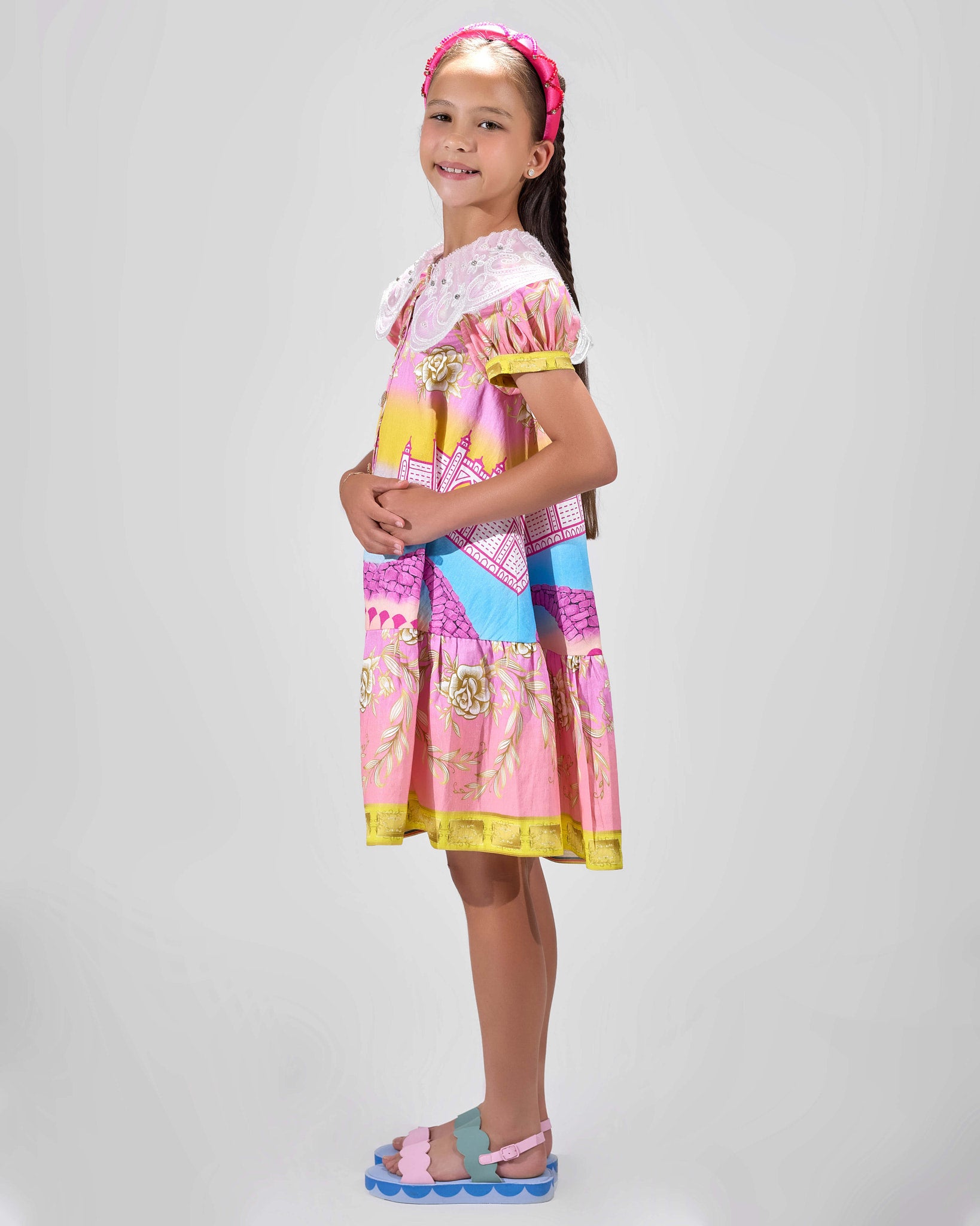 Girl in Dubai skyline print shirt dress with lace collar and puff sleeves.