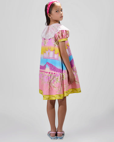 Girl in Dubai skyline print shirt dress with lace collar and puff sleeves.