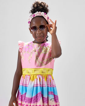 Girl in linen taffeta dress with Atlantis-themed print and white hem.