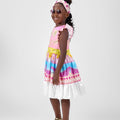 Girl in linen taffeta dress with Atlantis-themed print and white hem.