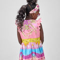 Girl in linen taffeta dress with Atlantis-themed print and white hem.