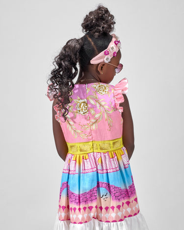 Girl in linen taffeta dress with Atlantis-themed print and white hem.