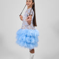 Young girl in a blue and white dress with a wand on a gray background
