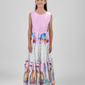 Girl in tiered Dubai-print maxi dress with lace panels and open-back tie.