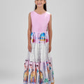 Girl in tiered Dubai-print maxi dress with lace panels and open-back tie.