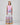 Girl in tiered Dubai-print maxi dress with lace panels and open-back tie.