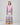 Girl in tiered Dubai-print maxi dress with lace panels and open-back tie.