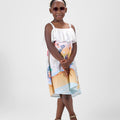 Girl in Dubai-themed crinkle taffeta dress with desert and skyline print.