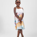 Girl in Dubai-themed crinkle taffeta dress with desert and skyline print.