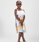 Girl in Dubai-themed crinkle taffeta dress with desert and skyline print.