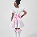 Girl in blush pink floral brocade dress with puff sleeves and organza bow.