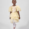 Product photo of a young girl modeling a yellow floral dress with ruffled sleeves, part of the Rehoboth Kidz summer collection, against a white background