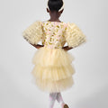 Young girl wearing a yellow dress with floral pattern and ruffled sleeves on a white background