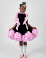 Girl in black velvet dress with pink organza ruffles and voluminous skirt.