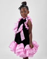 Girl in black velvet dress with pink organza ruffles and voluminous skirt.