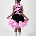Girl in black velvet dress with pink organza ruffles and voluminous skirt.