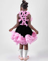 Girl in black velvet dress with pink organza ruffles and voluminous skirt.