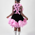 Girl in black velvet dress with pink organza ruffles and voluminous skirt.