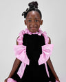 Girl in black velvet dress with pink organza ruffles and voluminous skirt.