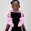 Girl in black velvet dress with pink organza ruffles and voluminous skirt.