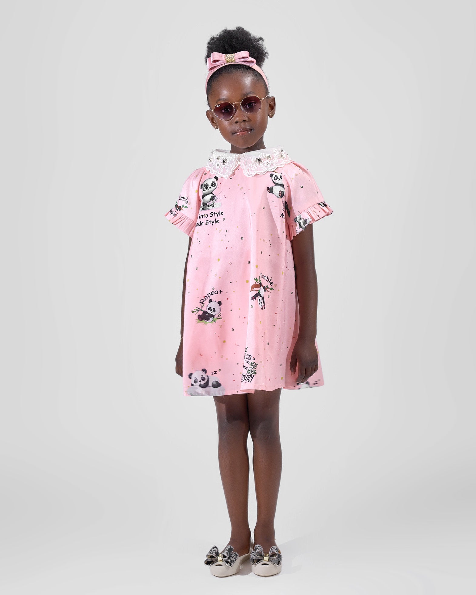 Girl in pink A-line dress with panda print and lace collar.
