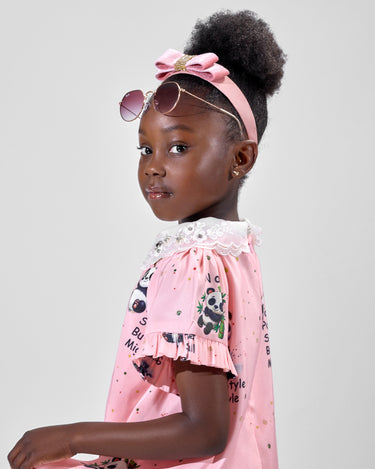Girl in pink A-line dress with panda print and lace collar.