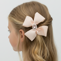 Blonde hair with a large pink bow accessory on a white background