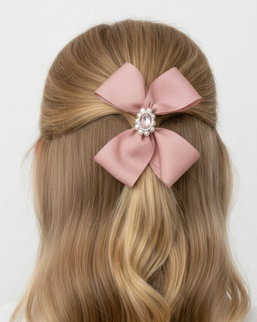 Blonde hair with a pink bow and pearl center against a white background
