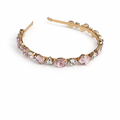 Gold hoop earring with pink gemstones on a white background